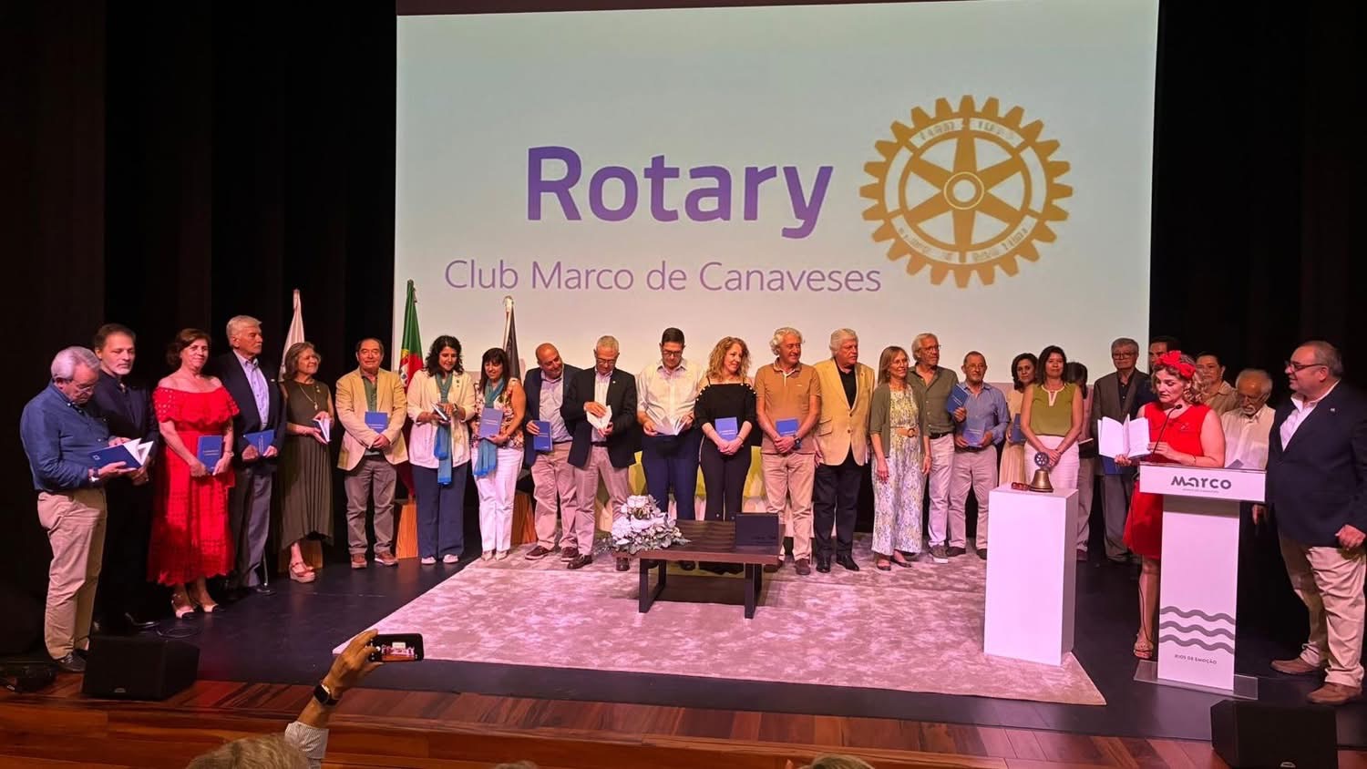 Participantes reunidos em palco com exemplares do livro